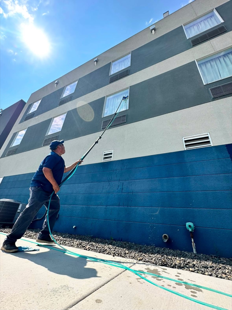 Summit View technician cleaning upper-story hotel windows in Wenatchee Valley