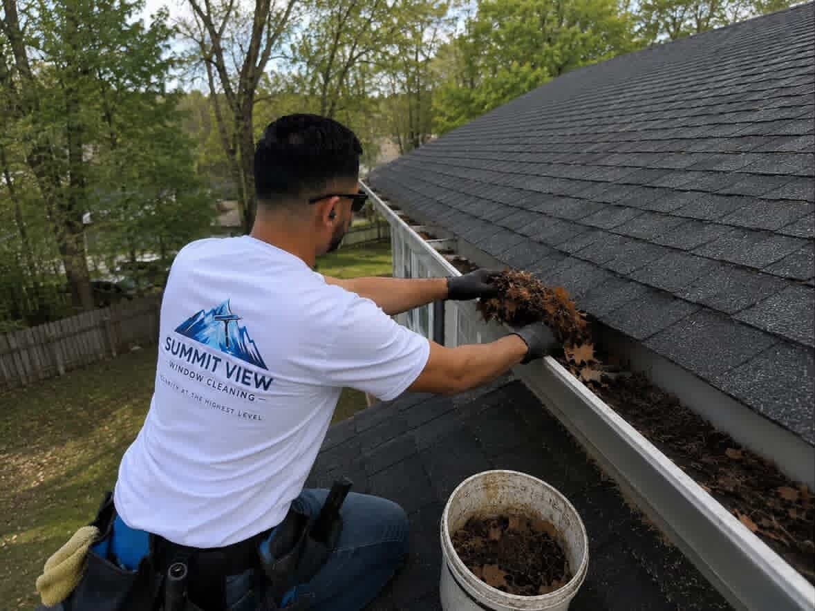 Summit View technician clearing leaves from a residential gutter