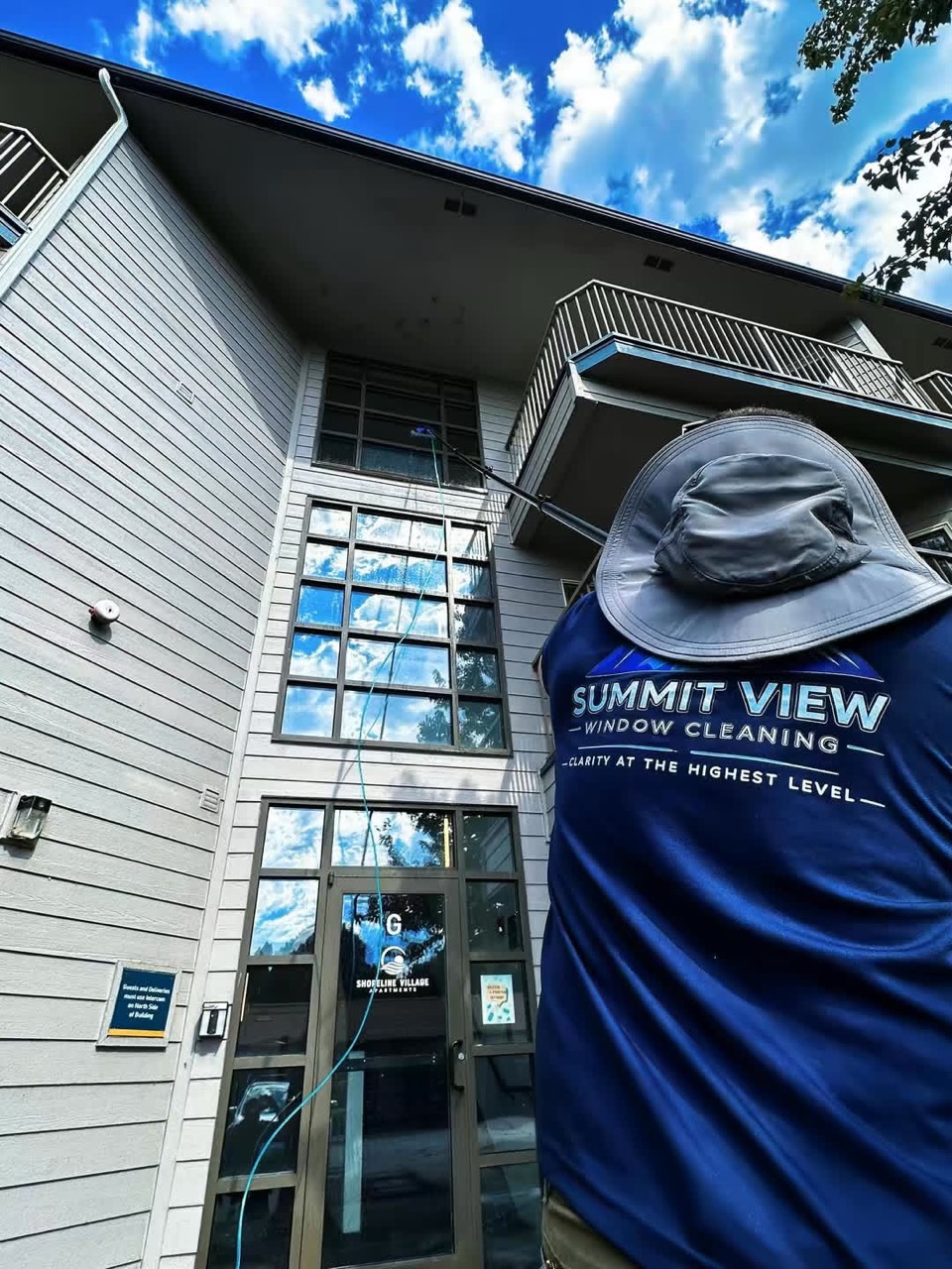Summit View technician cleaning multi-story windows in Wenatchee Valley